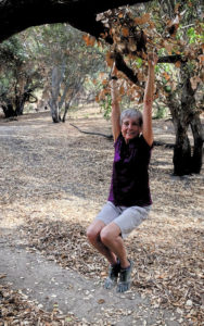 Joan hanging from a tree branch